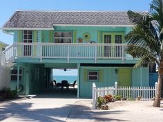 a blue and green house on the beach