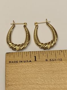 These fantastic hoop earrings are crafted from 10 karat yellow gold with silver accents at the center of each hoop. They have a textured finish and a twisted, rope like motif at the silver accented portion of each earring. These delightful earrings are eye-catching and unique and are sure to spark many a conversation. Their total weight together is 1.7 grams, and each hoop is approximately 0.65 inches across and 1 inch long. Both are in good to very good vintage condition, with minor, age approp Classic 14k Stamped Hoop Earrings, 14k Gold Stamped Hoop Jewelry, Formal 14k Gold Hallmarked Hoop Earrings, Small Hoop Earrings For Formal Events, Formal Small Hoop Pierced Earrings, Heirloom Hoop Jewelry For Anniversary, 14k Gold Hallmarked Hoop Jewelry, 14k Hoop Earrings For Anniversary, Hoop Earrings In 14k Gold