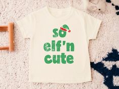 So Elf'in Cute Toddler Shirt, Kids Christmas Shirt, Toddler Christmas Shirt, Cute Kids Christmas Shirts, Holiday Shirts, Natural Toddler Tee 💗  Welcome to The WildflowerbyMiley Etsy Shop!  This listing is for the bodysuit, sweatshirt or t-shirt only. All other items that are shown in our photos such as shoes, hats, beanies, blankets etc. are for photo staging purposes and are NOT INCLUDED in the sale. DESCRIPTION:  This baby and children's unisex essential fits like a well-loved favorite. Super soft t-shirts, sweatshirts and baby bodysuits for your little lads and gals meant to showcase their big personalities. Its Excellent quality and vibrant print makes one fall in love with it over and over again.  This adorable piece is the perfect lightweight layer for casual wearing.  This product Kids Christmas Shirts, Toddler Christmas Shirt, Kids Christmas Shirt, Christmas Shirts For Kids, Wichita Ks, Toddler Christmas, Toddler Tees, Holiday Shirts, Kids T Shirts