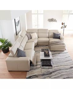 a living room with a large sectional couch and coffee table in the middle of it