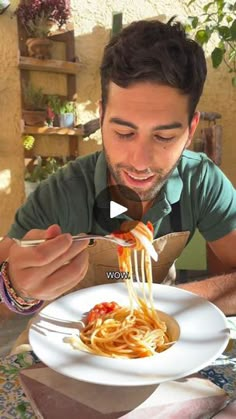 a man is eating spaghetti from a white plate