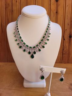 Emerald green colored crystal necklace and earring jewelry set.  Necklace is 18 inches non adjustable.  Green teardrop stones are .5 to 5 carats.  Square cut stones are 2mm to 3mm.  Center stone on earrings is 4 carats with clear crystal accents.  Earrings are 1.5 inches with a 1 inch drop.  Silver plated. Costume Jewelry With Crystal Gemstones, Elegant Teardrop Emerald And Diamond Necklace, Luxury Emerald Pear-shaped Jewelry, Luxury Pear-shaped Emerald Jewelry, Luxury Green Pear-shaped Jewelry, Elegant Emerald Necklace With Stones For Formal Events, Teardrop Crystal Jewelry With Stones, Teardrop Gemstone Jewelry For Formal Occasions, Emerald Drop Jewelry With 17 Jewels