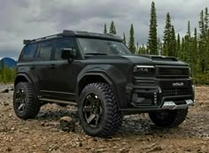 a black suv parked on top of a rocky field