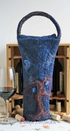 a wine bottle in a bag next to a glass of wine and some corks