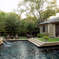 a backyard with a swimming pool surrounded by trees