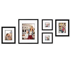 four black and white pictures hanging on the wall with one woman holding a child in her arms