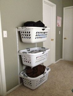 three laundry baskets stacked on top of each other in front of a door and closet