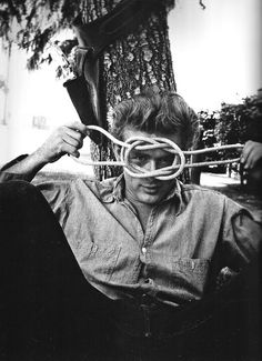 black and white photograph of a man with glasses on his face holding a pair of scissors