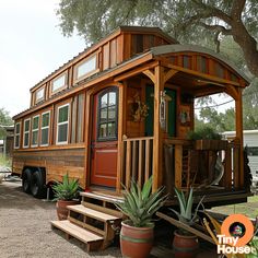 a tiny house on wheels with plants and potted cacti in the foreground