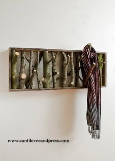 a scarf rack made from tree branches is hanging on the wall