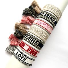 a stack of bracelets sitting on top of a white table next to each other