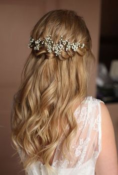 the back of a woman's head with long hair and flowers in her hair