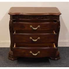 a wooden dresser with three drawers on top of carpeted flooring next to a white wall