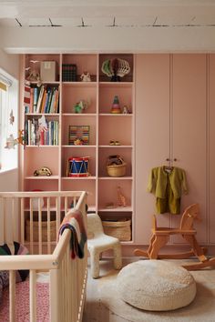 a baby's room with pink walls and furniture