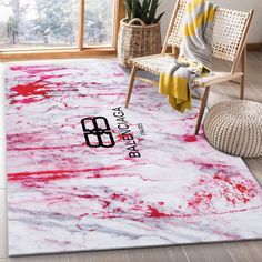 a white rug with red and black paint on it in a room next to a chair