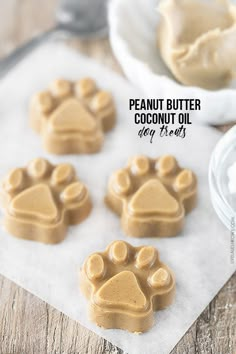 peanut butter coconut oil paw prints on wax paper with spoons in the background and text overlay that reads, peanut butter coconut oil paw prints