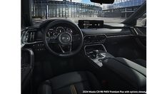 the interior of a car with dashboard, steering wheel and center console in front of an office building