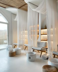 a room with white drapes and chairs