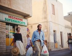 a man is walking down the street carrying shopping bags