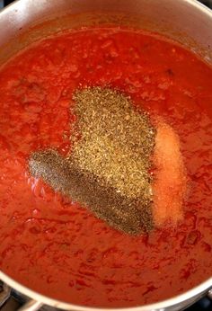 a pot filled with red sauce and spices