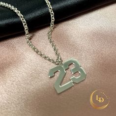 This Mens Number Necklace is a striking, unique piece of personalized jewelry that will make a statement.  Available in either sterling silver or 24K gold plated, this custom Boys Number Pendant is perfect for adding a personal touch to any outfit.  The necklace features a sturdy Rolo Chain that complements the pendant beautifully.  Treat yourself or a loved one to this special and meaningful piece, which makes for a thoughtful and stylish gift. M A T E R I A L S: Style: Number Necklace. Materia Bf Basket, Year Necklace, Custom Pendant, Number Necklace, Silver Numbers, Pendant For Men, Gifts For Sports Fans, North Hollywood, Custom Pendants