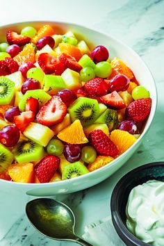 a white bowl filled with fruit and yogurt on top of a marble counter