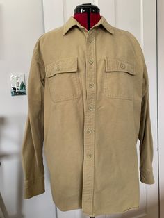 "Here is an L.L. Bean chamois shirt is khaki/ tan. It is made of cotton and is marked a size large. It measures approximately 48\" at the chest, 19\" across the shoulders, 23\" arm length, 7.5\" shoulder seam and 31\" center back length. It has some spots of discoloration on the right and left cuff and a small smudge on the left side about 5\" down from the pocket. Please see pictures." Chamois Shirt, Tan Shirt, Vintage Ll Bean, L L Bean, Flannel Shirt, Plaid Shirt, Float, Wool Blend, Ups