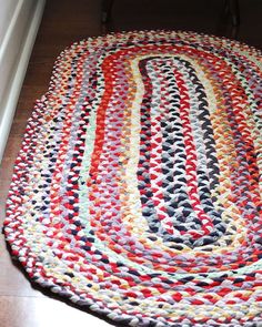 a multicolored rug is on the floor next to a chair