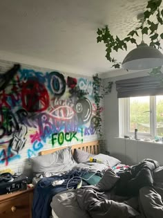 a messy bedroom with graffiti on the wall