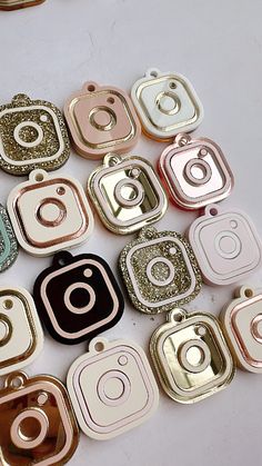 many different colors and sizes of square shaped buttons on a table with gold glitters