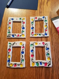 three decorated frames sitting on top of a wooden table