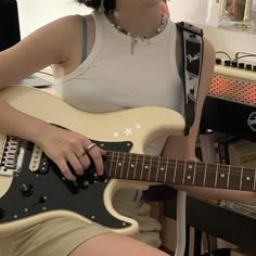 a woman is playing an electric guitar in her home