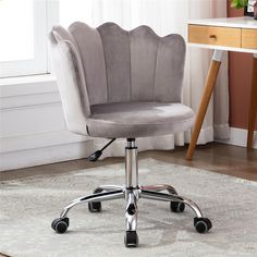 a gray office chair sitting on top of a white rug in front of a window