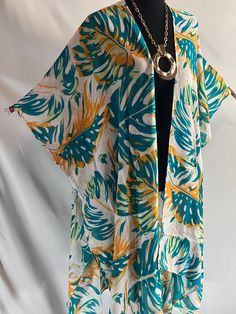 Embrace tropical elegance with our Monstera Print Tropical Style Kimono Blouse, an ideal addition to your summer wardrobe. This lightweight kimono is perfect for resort cruises, beach cover-ups, or any casual summer occasion. The vibrant monstera leaf print captures the essence of tropical paradise, adding a lively and artistic touch that art lovers will appreciate. Crafted from airy, breathable fabric, this summer kimono ensures you stay cool and comfortable even on the hottest days. Its versatile design allows it to transition seamlessly from a chic beach cover-up to a stylish layer over your favorite outfits. The flowing silhouette flatters all body types, and the open front design provides ease of wear and an effortlessly elegant look. Whether you're lounging by the beach, exploring tr Monstera Print, Kimono Beach Cover Up, Kimono Beach, Kimono Blouse, Blouse Summer, Summer Wraps, Summer Kimono, Blouse Style, Print Kimonos