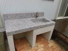 a bathroom sink sitting on top of a counter next to a brick flooring area