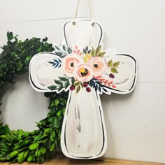 a cross hanging on the wall next to a wreath