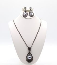 This jewelry set is a beautiful black earrings and necklace with a black pearl in the center. The earrings and necklace are made of high-quality materials and are sure to turn heads. Teardrop Metal Jewelry For Evening, Evening Teardrop Metal Jewelry, Elegant Black Jewelry Sets For Gifts, Elegant Black Jewelry Sets As A Gift, Black Teardrop Pendant Jewelry For Formal Occasion, Black Teardrop Pendant For Formal Occasions, Elegant Jewelry Sets With Teardrop Pendant For Party, Elegant Black Metal Jewelry, Elegant Gunmetal Jewelry For Formal Occasions