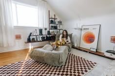 a woman is sitting on a bean bag chair in the living room with her legs crossed