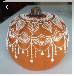 an orange painted pumpkin with white designs on it