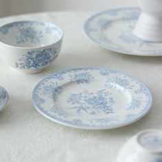 blue and white dishes are sitting on a table