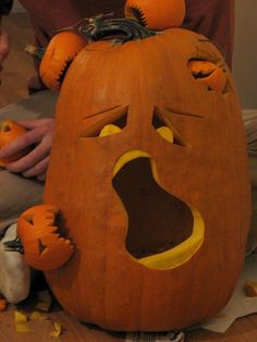 a pumpkin that has been carved to look like a face with its mouth open and eyes closed