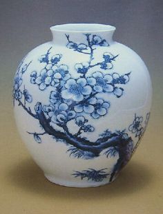 a blue and white vase sitting on top of a table next to a brown surface