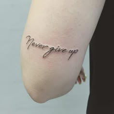 a woman's arm with the words never give up on it