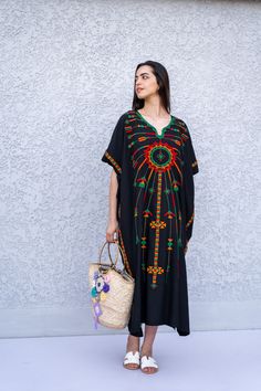 "This beautiful Kaftan with the Siwa inspired embroidery is a bohemian and flashy dress that will catch everyone's eyes. This Kaftan is ideal to wear for any casual occasion. Whether taking a trip down the shopping lane, or home-based kitty parties, or about anything else, wearing this dress will make you feel classy and comfortable. Fabric : 70% Egyptian Cotton; 30% Polyester. Size : Free sized dress. This Kaftan is a free sized dress meaning that it comes in one size only that fits any size fr Traditional Black Embroidered Thobe, Bohemian Cotton Kaftan With Embroidered Border, Black Embroidered Dress For Beach, Black Floral Embroidered Beach Dress, Black Floral Embroidered Dress For Beach, Black Kaftan For Festivals, Beach Black Embroidered Dress With Floral Details, Black Embroidered Dress With Floral Details For Beach, Black Beach Dress With Floral Embroidery