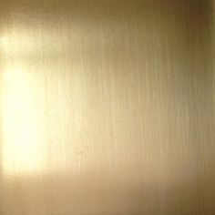 a close up view of a shiny metal surface with the light reflecting off it's side