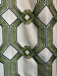 an upholstered fabric with green and white geometric designs on it's sides