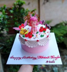 a hand holding a birthday card with a cake in the shape of a cupcake