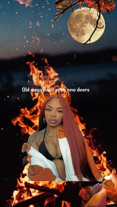 a woman with long red hair sitting in front of a fire and the moon above her