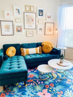 a living room with blue couches and pictures on the wall above it's coffee table