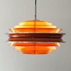 an orange light hanging from a ceiling fixture